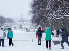 epa11053161 Tourists take pictures following a snowfall in Vigelandsparken in Oslo, Norway, 02 January 2024. EPA/HEIKO JUNGE NORWAY OUT