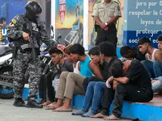 epa11067977 A police officer guards the detainees of an armed group for the temporary takeover of a television channel, in Guayaquil, Ecuador, 10 January 2024. The country is experiencing moments of great tension after the raid by an armed commando on TC Television in Guayaquil, which ended with the arrest of thirteen men and the release of the channel's staff. Ecuador is in a state of emergency for sixty days, which includes a curfew during the night and early morning, due to a series of incidents in prisons, which broke out on 08 January, and the ‘alleged escape’ of one of the most dangerous criminals from the country. Noboa declared on 09 January that government forces were engaged in an 'internal armed conflict' with armed criminal gangs, allowing him to use the Army and not just the Police to counter the violence. EPA/CARLOS DURAN ARAUJO