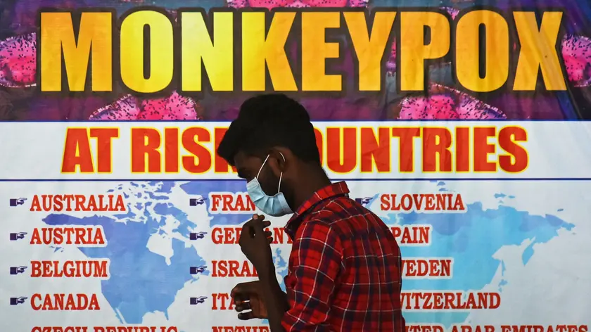 epa10334196 (FILE) - An Indian health worker walks in front of a list of high-risk countries for the Monkeypox virus, at Chennai International Airport, in Chennai, India, 16 July 2022 (reissued 28 November 2022). The World Health Organization (WHO) in a statement on 28 November 2022 said it "will begin using a new preferred term mpox as a synonym for monkeypox" simultaneously for one year until the term 'monkeypox' is phased out. The decsion was taken after consultations with global experts as "racist and stigmatizing language online, in other settings and in some communities was observed and reported to WHO." EPA/IDREES MOHAMMED