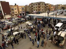 epa03964893 Libyan soldiers and civilians gather outside a hospital where people injured in clashes receive treatment following clashes between Libyan troops and radical militiamen in the eastern city of Benghazi, Libya, 25 November 2013. Media reports state seven soldiers were killed and 39 people injured in clashes between army forces and members of the jihadist Ansar al-Sharia group. The Libyan army declared a state of alert in Benghazi and ordered all soldiers to report for duty. EPA/STR