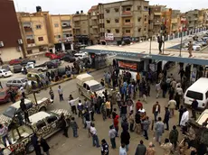 epa03964893 Libyan soldiers and civilians gather outside a hospital where people injured in clashes receive treatment following clashes between Libyan troops and radical militiamen in the eastern city of Benghazi, Libya, 25 November 2013. Media reports state seven soldiers were killed and 39 people injured in clashes between army forces and members of the jihadist Ansar al-Sharia group. The Libyan army declared a state of alert in Benghazi and ordered all soldiers to report for duty. EPA/STR
