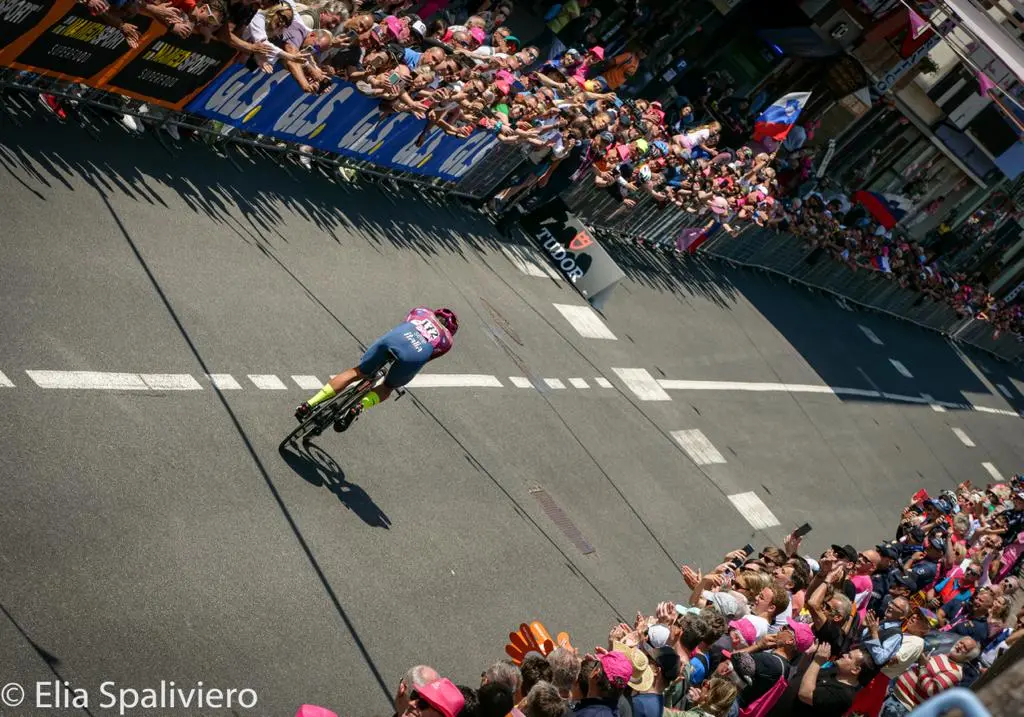 Splende il sole, intanto, in Friuli. Finalmente bel tempo sul Giro inseguito per giorni e giorni dalla pioggia nella sua risalita al Nord; spettacolo fino all’ultimo per una classifica apertissima come non mai. Tantissime le persone sulle strade, a Tarvisio e al Santuario, che applaudono i ciclisti ma soprattutto i due atleti friulani in gara, Alessandro De Marchi e Jonathan Milan, con la sua maglia ciclamino semplicemente passato in 21 tappe da esordiente a eroe acclamato da tutti e protagonista ieri dell’impresa del Giro arrivando in tempo massimo dopo una notte insonne. E poi turisti-tifosi in arrivo da Austria, soprattutto Slovenia per il loro Roglic; telespettatori incollati alle tv da tutto il mondo per assistere al debutto della misteriosa salita del Lussari, musica per le orecchie della Regione (Foto Petrussi)