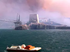 20070724 - PESCHICI (FOGGIA) - CRO : INCENDI: PUGLIA; CENTINAIA GLI ETTARI DISTRUTTI SUL GARGANO. Un pattino in mare a largo di Peschici, con il cielo coperto dal fumo degli incendi. ANSA / NICOLA LANESE / PAL