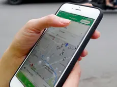Woman using the Grab app on an Apple iPhone 6 Ho Chi Minh City. Vietnam.