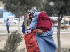 epa11324546 A burqa clad Afghan woman carries a child on a road in Kabul Afghanistan, 07 May 2024. Australia announced on 03 May it had committed to offering aid of AUD 492 million (USD 323 million) to reduce poverty in countries of the Indo-Pacific region through a fund from the Asian Development Bank. Australia has defended placing emphasis on mitigating the effects of the climate crisis and on the inclusion of new mechanisms to ensure the arrival of aid to people in Afghanistan, Myanmar and the Rohingya ethnic minority displaced in Bangladesh, with special emphasis on women and girls. EPA/SAMIULLAH POPAL