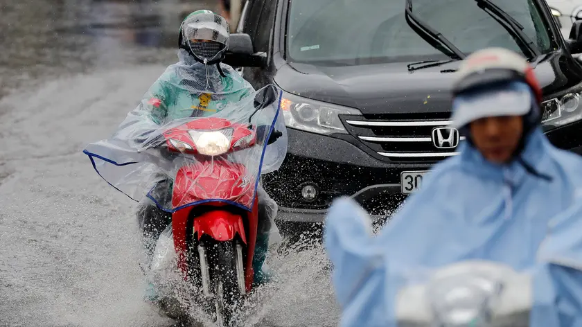 epa11590740 People ride motorbikes under the rain in Hanoi, Vietnam, 07 September 2024. Typhoon Yagi, Asia's most powerful storm so far this year, is expected to move deep into northern Vietnam after making landfall in Quang Ninh and Hai Phong on 07 September EPA/LUONG THAI LINH