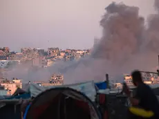epa11547889 Smoke rises following an Israeli air strike as internally displaced Palestinians sit next to their tents in Khan Younis camp, southern Gaza Strip, 13 August 2024. More than 39,900 Palestinians and over 1,400 Israelis have been killed, according to the Palestinian Health Ministry and the Israel Defense Forces (IDF), since Hamas militants launched an attack against Israel from the Gaza Strip on 07 October 2023, and the Israeli operations in Gaza and the West Bank which followed it. EPA/HAITHAM IMAD