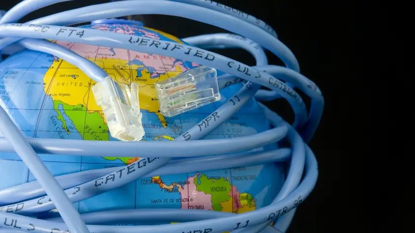 Network cable wrapped around a globe depicting a connected world