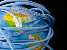 Network cable wrapped around a globe depicting a connected world