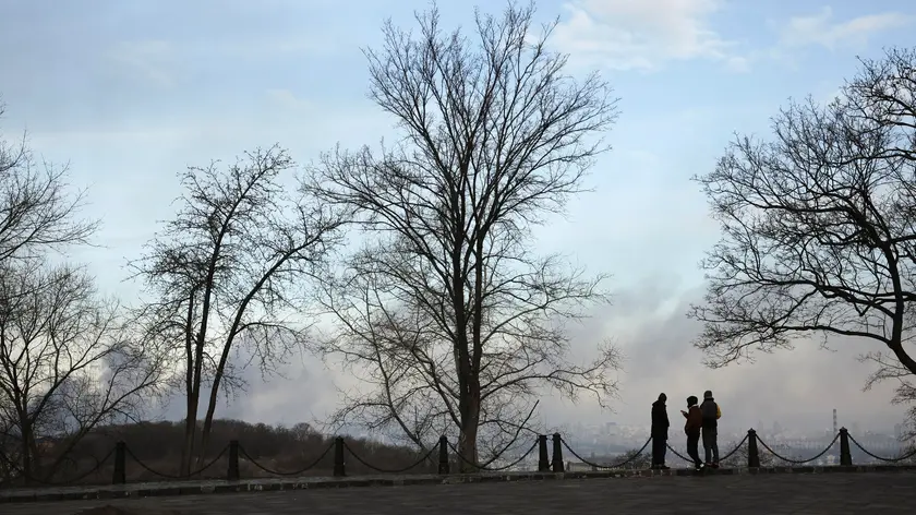 epa11047839 People stand in an area overlooking smoke rising over the city after shelling hit Kyiv (Kiev), Ukraine, 29 December 2023, amid the Russian invasion. At least 12 people have died and dozens more injured after Russia launched a wave of airstrikes across Ukraine, Ukrainian authorities said on 29 December. Strikes were reported in Kyiv, Lviv, Odesa, Dnipro, Kharkiv, Zaporizhzhia, and other Ukrainian cities. In the Ukrainian captital Kyiv, the districts of Sviatoshynskyi, Podilskyi and Shevchenkivskyi came under fire killing at least two people and injuring 18 others, the Ukrainian Ministry of the Internal Affairs wrote on telegram. President Zelensky said that around 110 missiles were fired against Ukraine, with 'the majority of them being shot down'. Russian troops entered Ukraine on 24 February 2022 starting a conflict that has provoked destruction and a humanitarian crisis. EPA/OLEG PETRASYUK