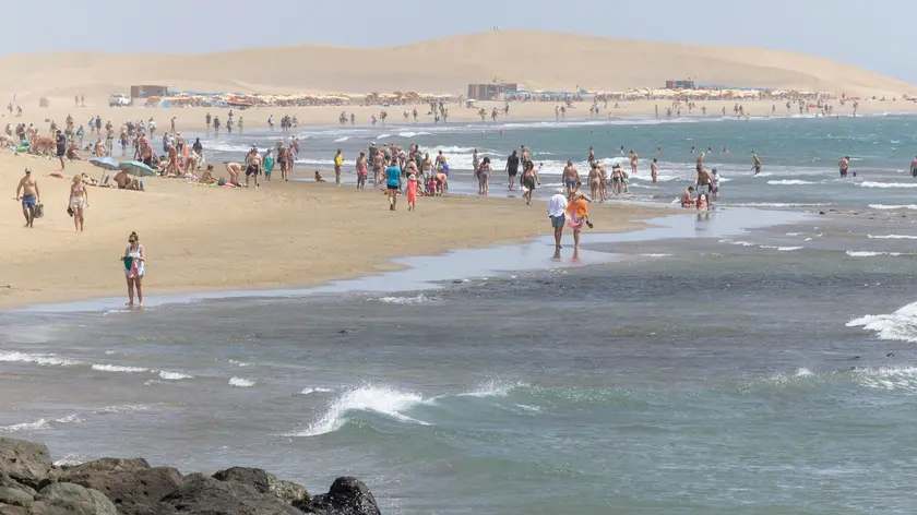 epa10899545 People visit a beach in Maspalomas town, Gran Canaria island, Canary Islands, Spain, 04 October 2023. Authorities activated the orange alert in the Canary Islands due to temperatures over 37 degrees Celsius. EPA/Quique Curbelo