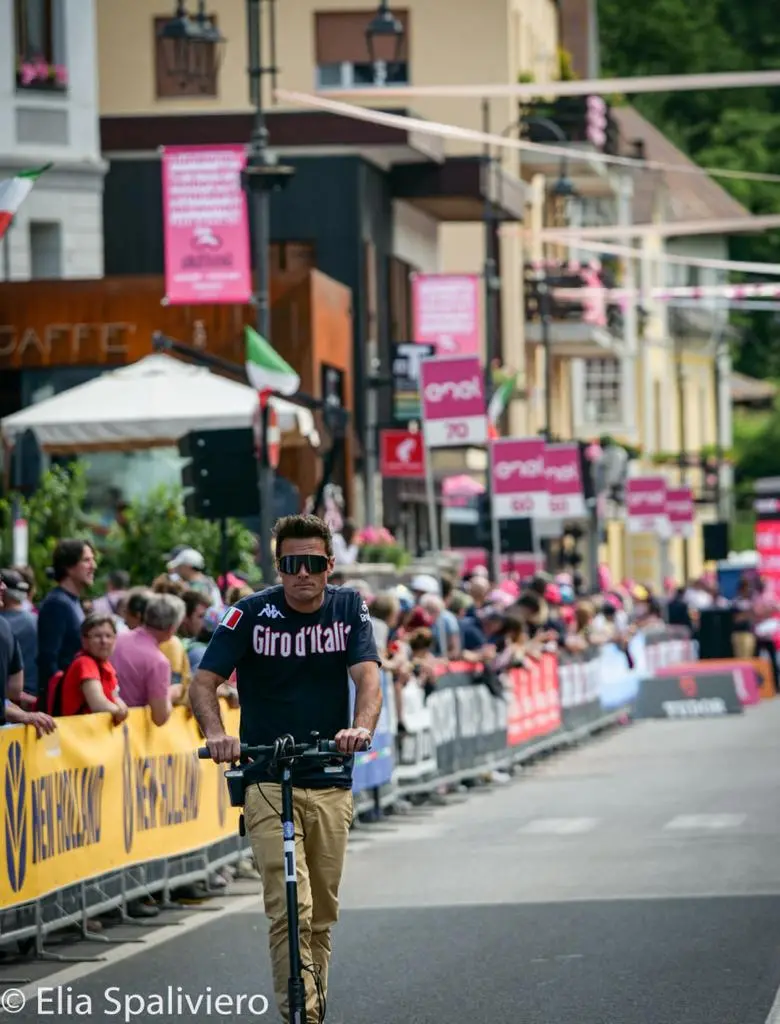 Splende il sole, intanto, in Friuli. Finalmente bel tempo sul Giro inseguito per giorni e giorni dalla pioggia nella sua risalita al Nord; spettacolo fino all’ultimo per una classifica apertissima come non mai. Tantissime le persone sulle strade, a Tarvisio e al Santuario, che applaudono i ciclisti ma soprattutto i due atleti friulani in gara, Alessandro De Marchi e Jonathan Milan, con la sua maglia ciclamino semplicemente passato in 21 tappe da esordiente a eroe acclamato da tutti e protagonista ieri dell’impresa del Giro arrivando in tempo massimo dopo una notte insonne. E poi turisti-tifosi in arrivo da Austria, soprattutto Slovenia per il loro Roglic; telespettatori incollati alle tv da tutto il mondo per assistere al debutto della misteriosa salita del Lussari, musica per le orecchie della Regione (Foto Petrussi)