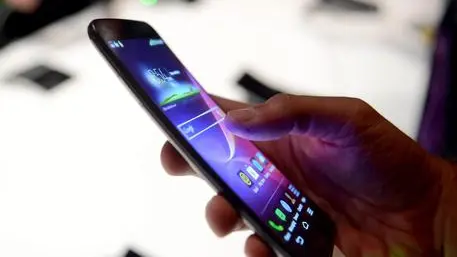 A journalist tries out the new LG G Flex Android Smartphone featuring a curved, flexible body and screen during a media presentation at the consumer electronics show CES in Las Vegas, USA, 06 January 2014.ANSA/BRITTA PEDERSEN