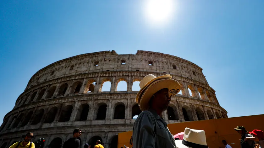 Tourists and street vendors at the Colosseum during a a heat wave in Rome, Italy 29 July 2023. (Colosseo, cappelli, cappello, caldo, afa, turisti, refrigerio, canicola, ombrelli, sole) ANSA/FABIO FRUSTACI
