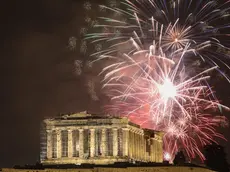 epa11051408 Fireworks illuminate the Athenian sky over the Acropolis hill, during the New Year celebrations in Athens, Greece, 01 January 2024. EPA/GEORGE VITSARAS