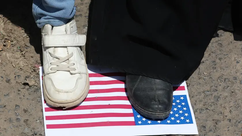 epa11584657 Students stand over a poster with a US flag during a protest in solidarity with the Palestinian people, at Sanaa University, in Sanaa, Yemen, 04 September 2024. University students and academics have staged a protest at Sana'a University to express their solidarity with the Palestinian people in the Gaza Strip. More than 40,000 Palestinians and over 1,400 Israelis have been killed, according to the Palestinian Health Ministry and the Israel Defense Forces (IDF), since Hamas militants launched an attack against Israel from the Gaza Strip on 07 October 2023, and the Israeli operations in Gaza and the West Bank which followed it. EPA/YAHYA ARHAB