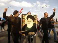 epa08200796 Iraqi protesters carry a picture of Iraqi Shiite Muslim spiritual leader Sayyid Ali Husseini Sistani during a protest in Basra city, southern Baghdad, Iraq, 07 February 2020. The United Nations Assistance Mission to Iraq (UNAMI) and the US embassy in Iraq have condemned the killing of 12 protesters in Najaf, after the supporters of Shia leader Muqtada al-Sadr stormed protests camp to forcibly remove demonstrators from the site. EPA/STR