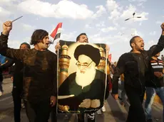 epa08200796 Iraqi protesters carry a picture of Iraqi Shiite Muslim spiritual leader Sayyid Ali Husseini Sistani during a protest in Basra city, southern Baghdad, Iraq, 07 February 2020. The United Nations Assistance Mission to Iraq (UNAMI) and the US embassy in Iraq have condemned the killing of 12 protesters in Najaf, after the supporters of Shia leader Muqtada al-Sadr stormed protests camp to forcibly remove demonstrators from the site. EPA/STR
