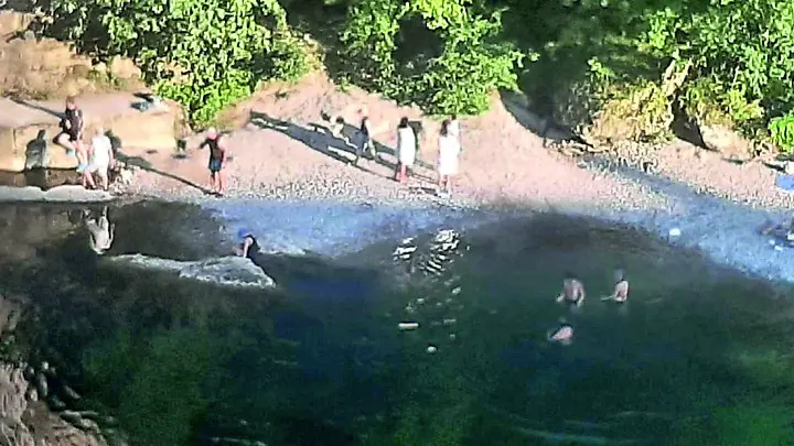 I bagnanti che, incuranti del divieto, si sono immersi nelle acque del Natisone sotto il ponte del Diavolo