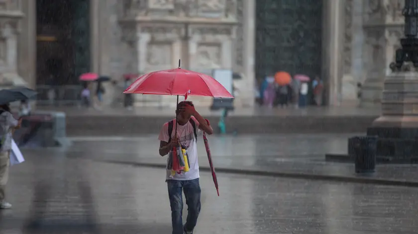 Turisti e cittadini si riparano dalla pioggia a Milano, 28 agosto 2023. ANSA/DAVIDE CANELLA