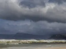 epa05281391 A north westerly wind fans waves breaking on Muizenberg beach as a storm front approaches Cape Town, South Africa 28 April 2016. The Western Cape Disaster Management Centre has warned of cold conditions with rain and snow with a possible risk of floods from the second big winter front hitting the Cape. EPA/NIC BOTHMA