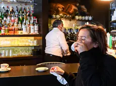 A woman drinks a coffe inside a bar in the centre of town as Regione Liguria shifts to ÒYellow ZoneÓ following government decisions in order to contain the Coronavirus pandemic, in Genoa, Italy, 29 November 2020 ANSA/SIMONE ARVEDA