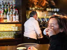 A woman drinks a coffe inside a bar in the centre of town as Regione Liguria shifts to ÒYellow ZoneÓ following government decisions in order to contain the Coronavirus pandemic, in Genoa, Italy, 29 November 2020 ANSA/SIMONE ARVEDA