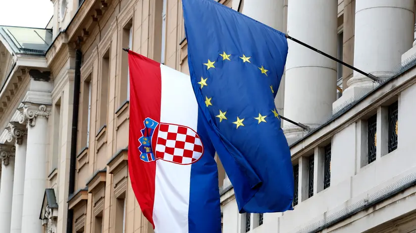 The flags of Croatia (L) and European Union (EU) hang from the facade of the Parliament building at old town in Zagreb, Croatia, 20 May 2022. Croatia, which joined the EU in 2013, is set to join the Eurozone in January 2023, with the introduction of the euro as the country's official currency after Croatian lawmakers voted in favor of legislation to bring the shared currency. ANSA/ANTONIO BAT