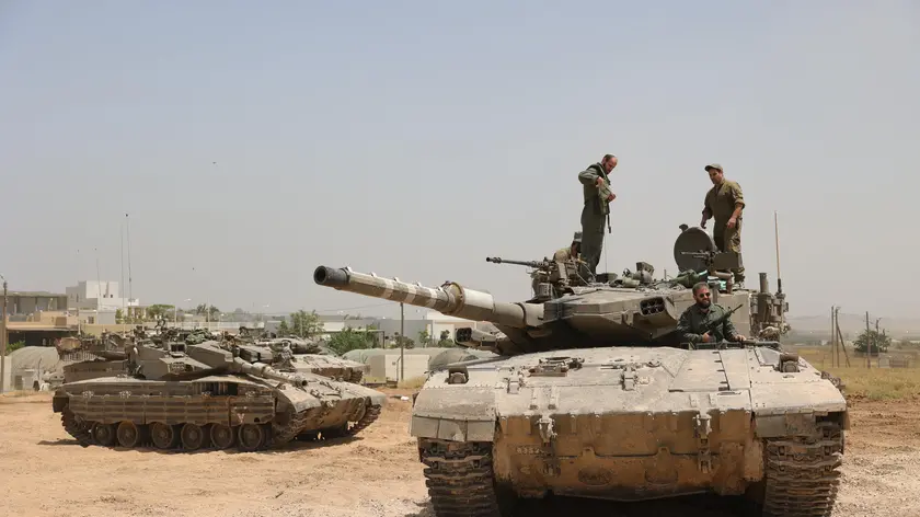 epa11357607 Israeli soldiers with their tanks gather at an undisclosed location near the border fence with the Gaza Strip, in southern Israel, 21 May 2024. The Israeli military stated on 21 May that they continued 'operational activities' throughout the Gaza Strip over the past day, where they dismantled some 70 targets. More than 35,000 Palestinians and over 1,400 Israelis have been killed, according to the Palestinian Health Ministry and the Israel Defense Forces (IDF), since Hamas militants launched an attack against Israel from the Gaza Strip on 07 October 2023, and the Israeli operations in Gaza and the West Bank which followed it. EPA/ABIR SULTAN