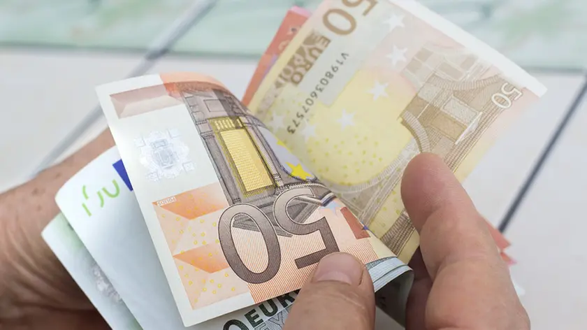 Close-up view of unrecognizable man counting money. Horizontal composition. Studio shot. Image developed from RAW format.