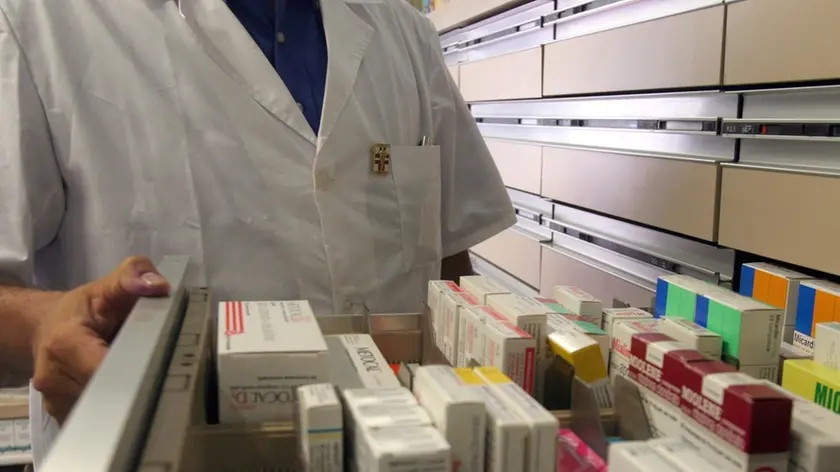 20080627 - ROMA FARMACI: NEL 2007 525 DOSI A TESTA, 7 SU 10 DA SSN - Un farmacista mostra i medicinali contenuti in una cassetiera . Sempre piu' farmaci nella vita degli italiani: ognuno ne ha assunto, in media, nel 2007 una pillola e mezza al giorno (525 dosi), facendo crescere i consumi di farmaci di classe A del 3 per cento. Ma la spesa complessiva si e' comunque abbassata di due punti e mezzo rispetto al 2006 (-2,6%), con i risultati migliori in termini di risparmio proprio per la spesa pubblica, diminuita del 5,4 per cento. VIRGINIA FARNETI/ARCHIVIO ANSA/ ji
