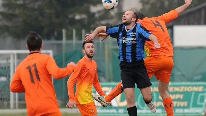 Manzano, 12 gennaio 2013. Calcio - Dilettanti. Manzanese (arancio) vs Rivignano (nero-blu). Nella foto il n4 della Manzanese vs il n4 del Rivignano. Copyright Foto Petrussi / Ferraro Simone