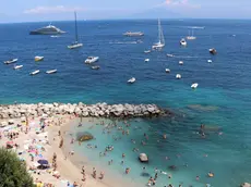 People on the beach enjoy a hot and sunny day in Capri, southern Italy, during Ferragosto, 15 August 2023. Ferragosto is an Italian public holiday celebrated on 15 August every year, coinciding with the major Catholic feast of the Assumption of Mary. It marks the peak of the summer vacation period. ANSA/ GIUSEPPE CATUOGNO