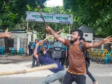 epa11524745 A protester shouts slogans as police look on during the first day of the non-cooperation movement in Dhaka, Bangladesh, 04 August 2024. The Anti-Discrimination Student Movement organizers are demanding the resignation of the current government. Dhaka authorities have imposed a new curfew starting 06:00 p.m. local time on 04 August. As casualties mounted and law enforcement struggled to contain the unrest, the Bangladeshi government on 20 July 2024 had imposed an initial nationwide curfew and deployed military forces after violence broke out in Dhaka and other regions following student-led protests demanding reforms to the government's job quota system. EPA/MONIRUL ALAM