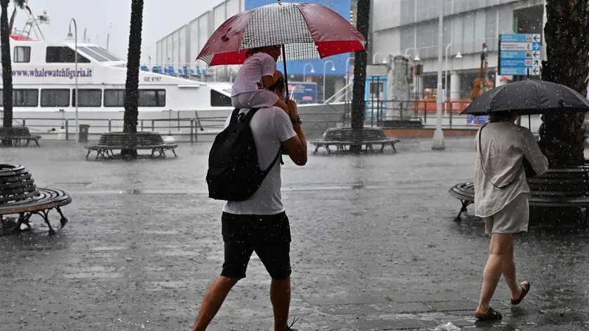 Genovesi e turisti tentano di ripararsi dalla pioggia, Genova, 30 giugno 2023. Un forte temporale si è abbattuto su Genova che, come tutto il territorio ligure, è sotto allerta gialla dalle 6 di questa mattina./// Genoese citizens and tourists try to shelter from the rain, in Genoa, Italy, 30 June 2023. A strong storm hit Genoa which, like the whole Ligurian territory, has been under yellow alert since 6 a.m. ANSA/LUCA ZENNARO