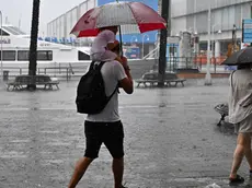 Genovesi e turisti tentano di ripararsi dalla pioggia, Genova, 30 giugno 2023. Un forte temporale si è abbattuto su Genova che, come tutto il territorio ligure, è sotto allerta gialla dalle 6 di questa mattina./// Genoese citizens and tourists try to shelter from the rain, in Genoa, Italy, 30 June 2023. A strong storm hit Genoa which, like the whole Ligurian territory, has been under yellow alert since 6 a.m. ANSA/LUCA ZENNARO