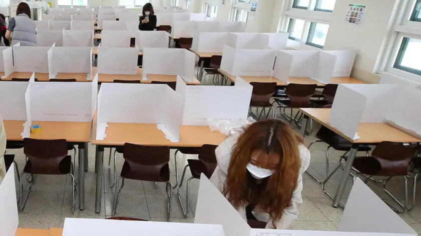 epa08418508 Teachers set up dividers on tables in a cafeteria of Duksoo High School in Seoul, South korea, 13 May 2020. The school will reopen on 20 May 2020. EPA/YONHAP SOUTH KOREA OUT