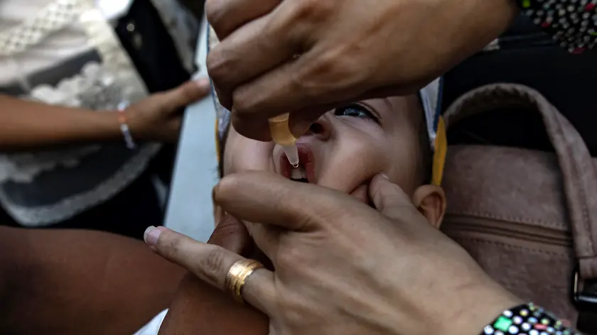epa11586258 A nurse administers polio vaccine drops to Palestinian children at a UN school in Khan Yunis camp, southern Gaza Strip, 05 September 2024. According to UNICEF Regional Director for the Middle East and North Africa, Adele Khodr, the first phase of a two-round polio vaccination campaign, running from 01 to 03 September, surpassed its initial target (estimated at 157,000 children due to population movement) and reached more than 189,000 children under 10 years old in the central Gaza Strip. The rollout of the next phase of the campaign will take place in southern Gaza from 05 to 08 September 2024, targeting an estimated 340,000 children under the age of 10, the World Health Organization (WHO) said. To prevent the spread of circulating variant type 2 poliovirus (cVDPV2), a polio vaccination campaign with novel oral poliovirus vaccine type 2 (nOPV2) has been launched in the Palestinian enclave after WHO and UNICEF called for humanitarian pauses in the conflict to allow for vaccination following the discovery of the poliovirus in environmental samples from Khan Yunis and Deir Al Balah in July 2024. EPA/HAITHAM IMAD
