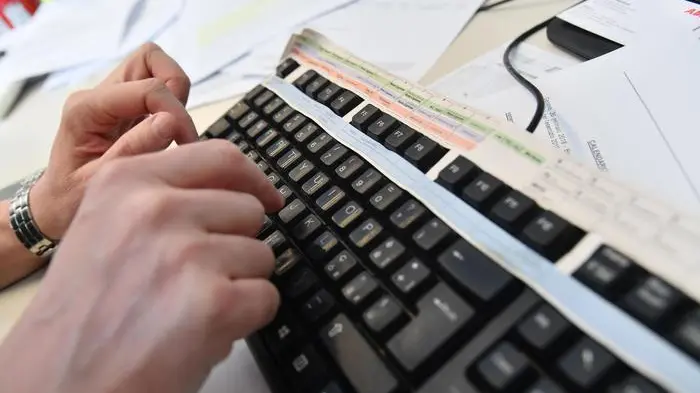 Un impiegato lavora al computer nel suo ufficio, 19 marzo 2018 a Genova..ANSA/LUCA ZENNARO
