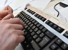 Un impiegato lavora al computer nel suo ufficio, 19 marzo 2018 a Genova..ANSA/LUCA ZENNARO