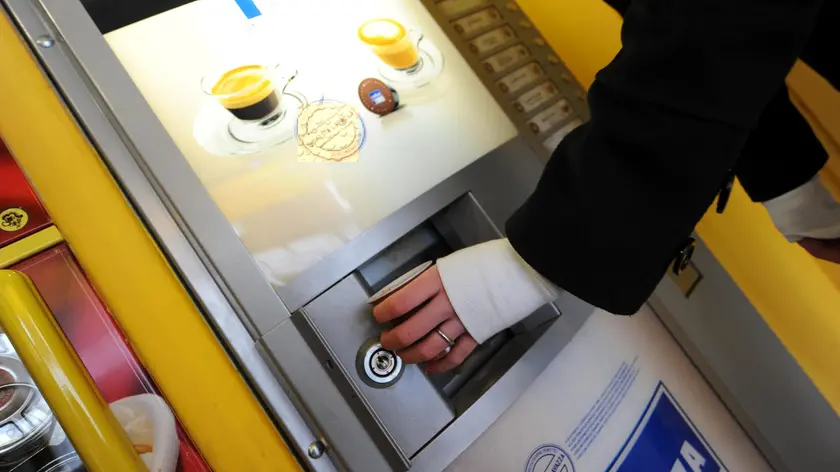 Un distributore automatico di caffe' in un'immagine d'archivio del 25 gennaio 2009 a Livorno. Il prezzo del caffe' ai distributori automatici potrebbe crescere a breve di circa 15/20 centesimi. Lo annuncia la Confida, associazione della Confcommercio che si occupa dei distributori automatici (due milioni di macchine installate in Italia per due miliardi di euro di fatturato). L'aumento dei prezzi, spiega l'associazione, e' legato ai rincari delle materie prime, caffe' e zucchero in particolare ma anche a quello della plastica e alla crescita del prezzo dei carburanti, essenziali in questo settore dato che i distributori sono costantemente riempiti grazie al trasporto dei prodotti da parte degli addetti del settore (circa 35.000). ANSA / FRANCO SILVI