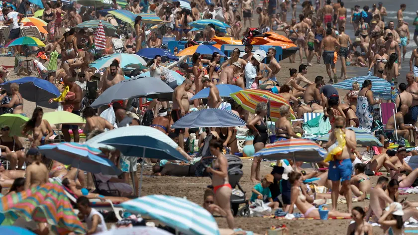 epa10762882 Hundreds enjoy the weekend at Malvarrosa beach, in Valencia, eastern Spain, 22 July 2023. A seasonal heatwave hit Spain with temperatures above 30 degrees Celsius in most parts of the country. EPA/KAI FORSTERLING