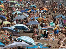 epa10762882 Hundreds enjoy the weekend at Malvarrosa beach, in Valencia, eastern Spain, 22 July 2023. A seasonal heatwave hit Spain with temperatures above 30 degrees Celsius in most parts of the country. EPA/KAI FORSTERLING