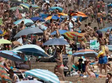 epa10762882 Hundreds enjoy the weekend at Malvarrosa beach, in Valencia, eastern Spain, 22 July 2023. A seasonal heatwave hit Spain with temperatures above 30 degrees Celsius in most parts of the country. EPA/KAI FORSTERLING