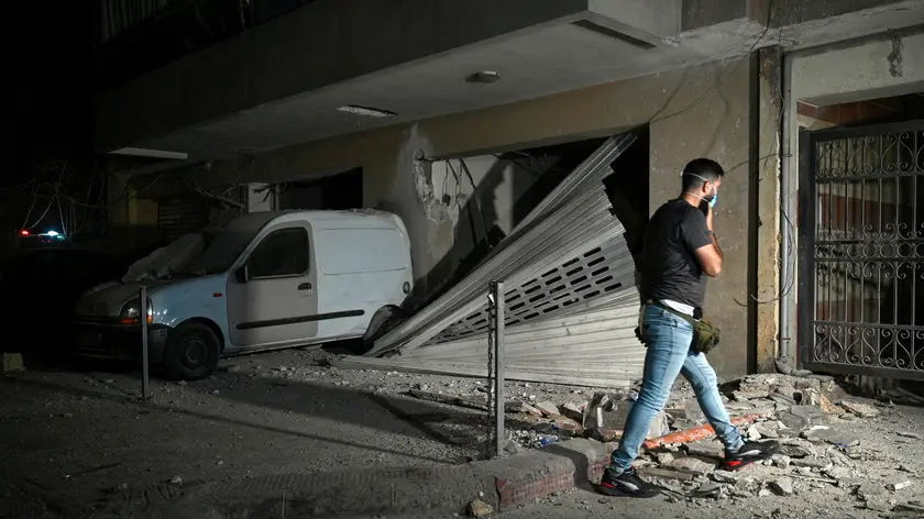 epa11621285 A man walks next to a damaged vehicle at the southern suburb of Beirut after an Israeli military strike, in Beirut, Lebanon, 23 September 2024. The Israeli Defense Forces (IDF) said they conducted a 'targeted strike' in Beirut on 23 September after the Israeli military announced that it launched 'extensive' airstrikes on Hezbollah targets in Lebanon. Lebanese residents of villages in the Beqaa Valley 'who are inside or near houses where rockets and weapons are stored' have been warned to 'move away immediately! For your safety and protection', the statement added. According to Lebanon's Ministry of Health, at least 274 people have been killed and more than 1,000 others injured following continued Israeli airstrikes on southern Lebanese towns and villages since 23 September morning. EPA/WAEL HAMZEH