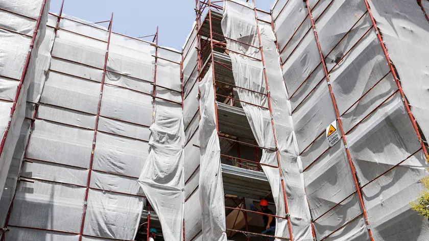 Builders from Pierluigi Fusco's firm work at a construction site of energy-saving building, making apartments more energy-efficient under government "superbonus" incentives, in Caserta, southern Italy, June 21, 2022. Picture taken June 21, 2022. REUTERS/Remo Casilli