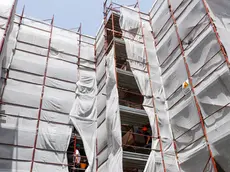 Builders from Pierluigi Fusco's firm work at a construction site of energy-saving building, making apartments more energy-efficient under government "superbonus" incentives, in Caserta, southern Italy, June 21, 2022. Picture taken June 21, 2022. REUTERS/Remo Casilli