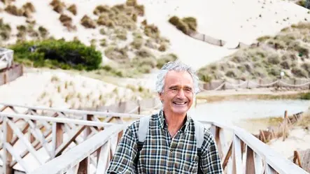 Middle- aged man practicing nordic walking on wooden pier --- Image by © Norbert Schaefer/Corbis