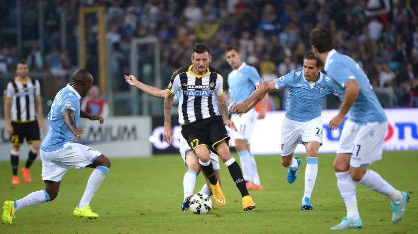 Udinese's Cyril Thereau (C) contrastated by Lazio's Edson Braafheid (L) and Cristian Ledesma during the Italian Serie A soccer match SS Lazio vs Udinese Calcio at Olimpico stadium in Rome, Italy, 25 september 2014..ANSA/MAURIZIO BRAMBATTI