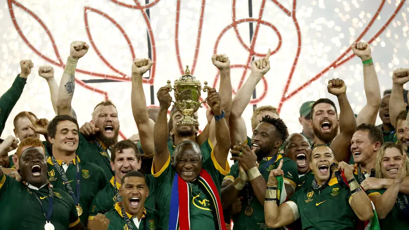 epa10946197 South African President Cyril Ramaphosa lifts the Webb Ellis trophy standing next to the team's captain Siya Kolisi (C right) after the team won the Rugby World Cup 2023 final between New Zealand and South Africa in Saint-Denis, France, 28 October 2023. EPA/YOAN VALAT
